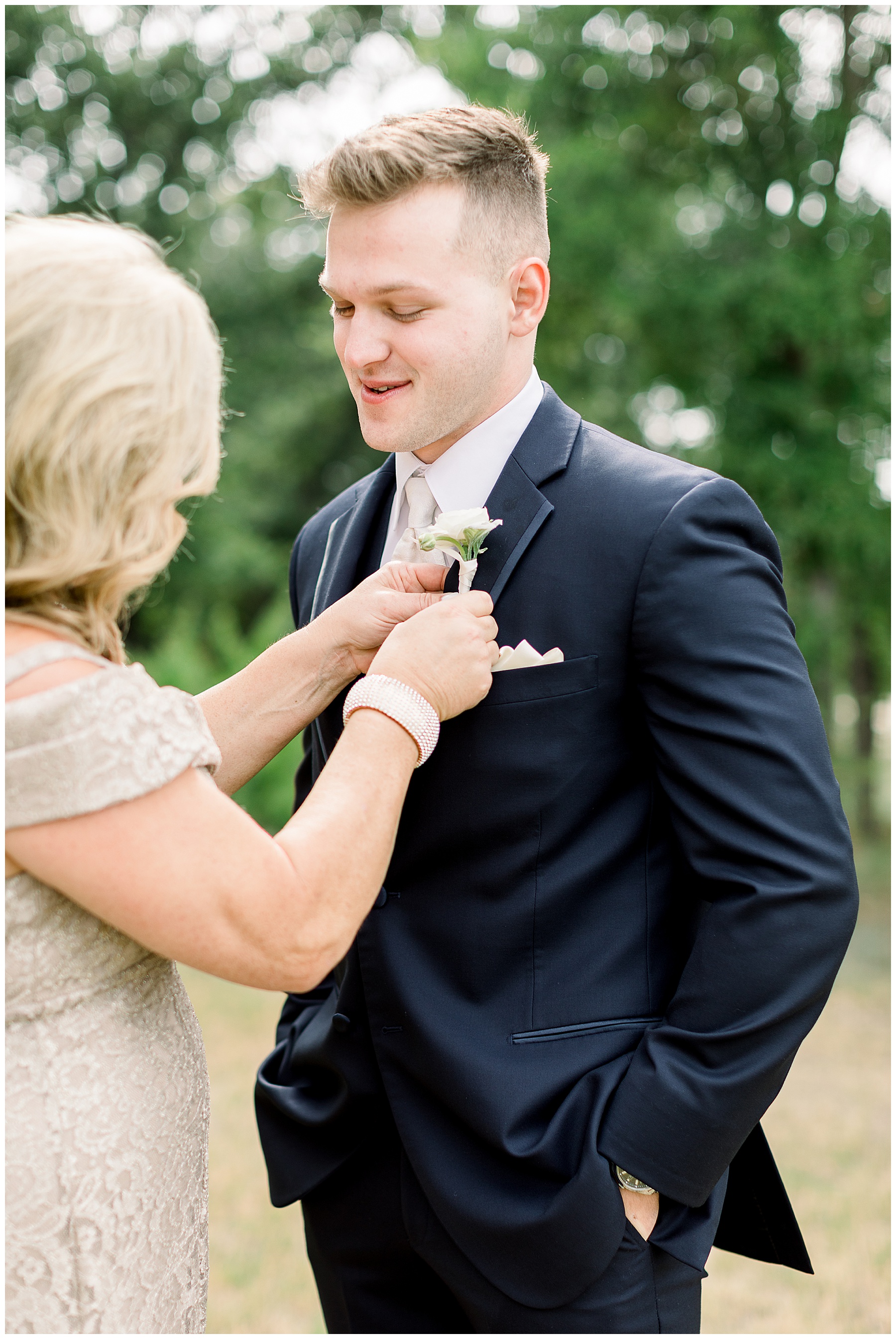 mother of the groom pinning flower to groom