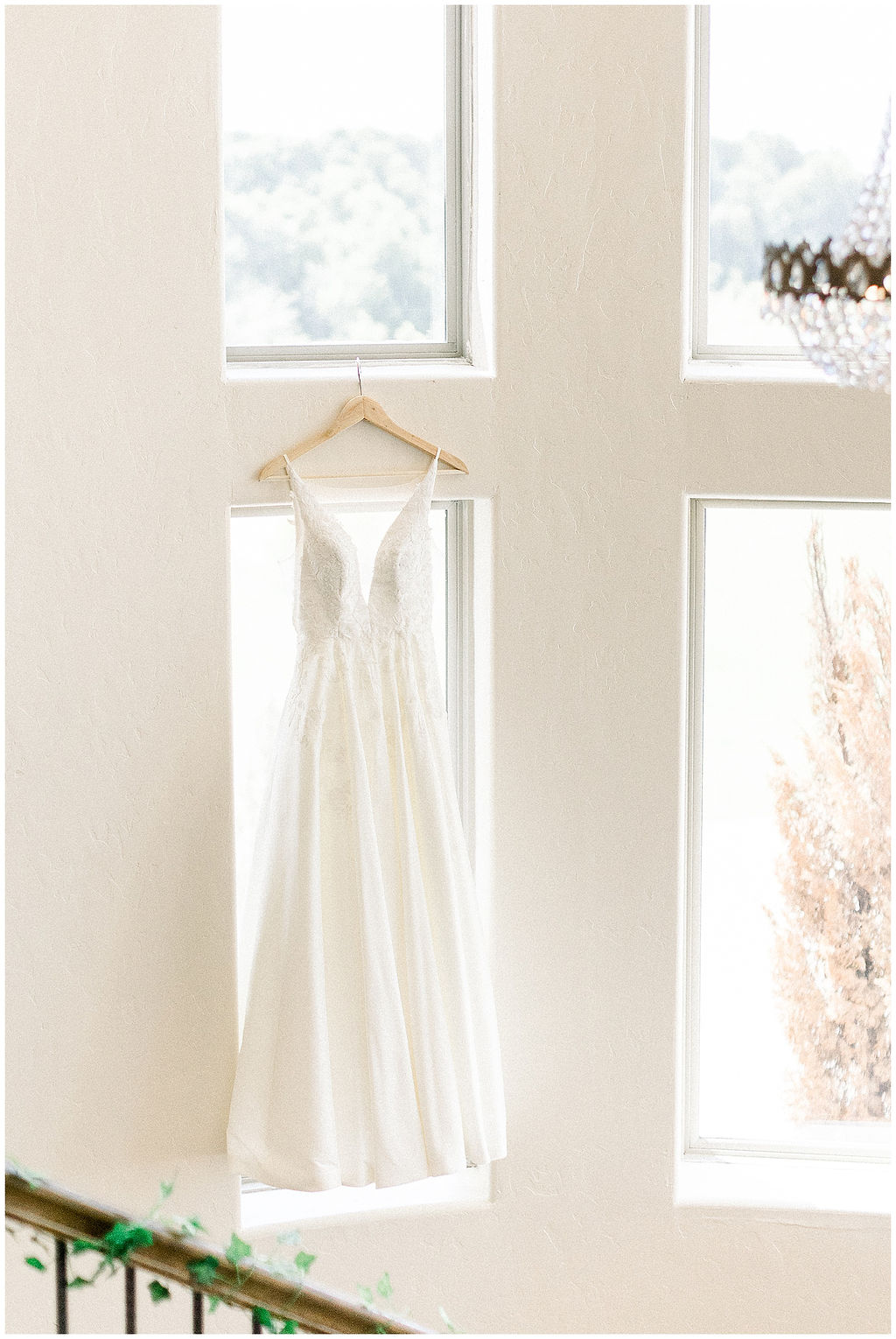wedding gown hangs in front of window