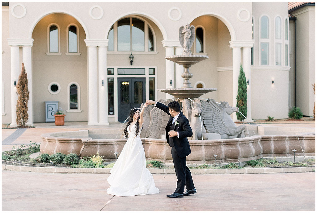 bride and groom dance in front of fountain