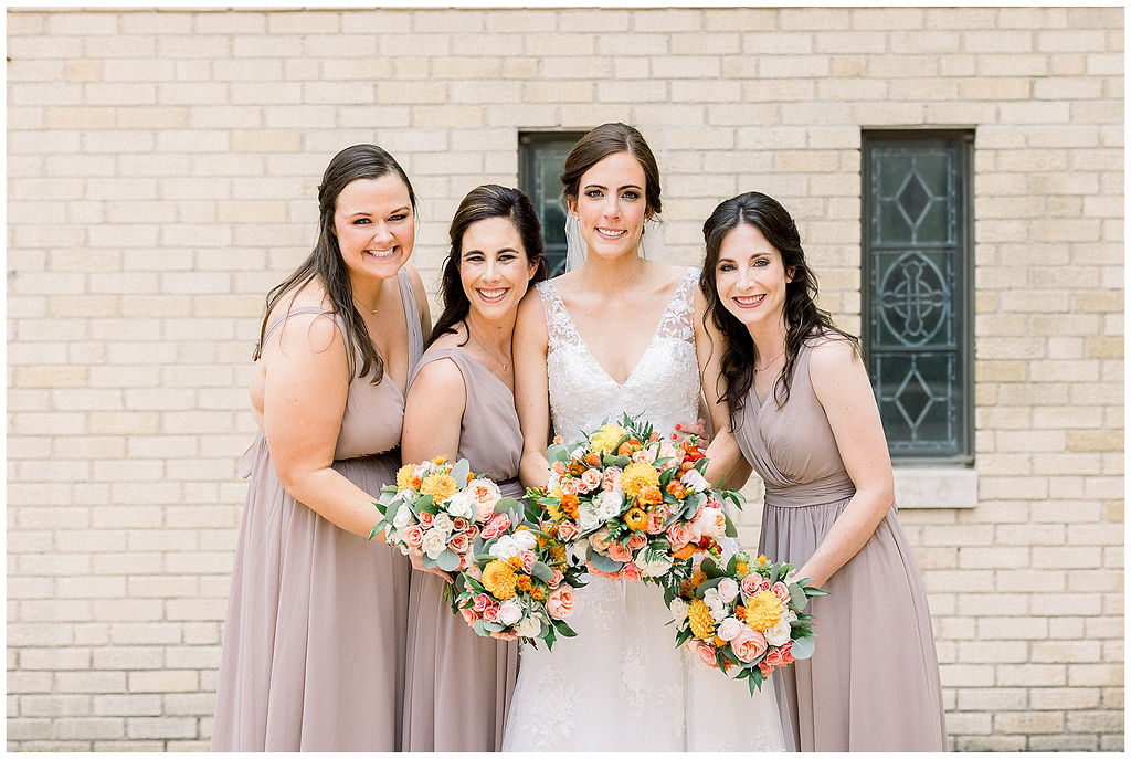 bridesmaids pose with bride and bouquets