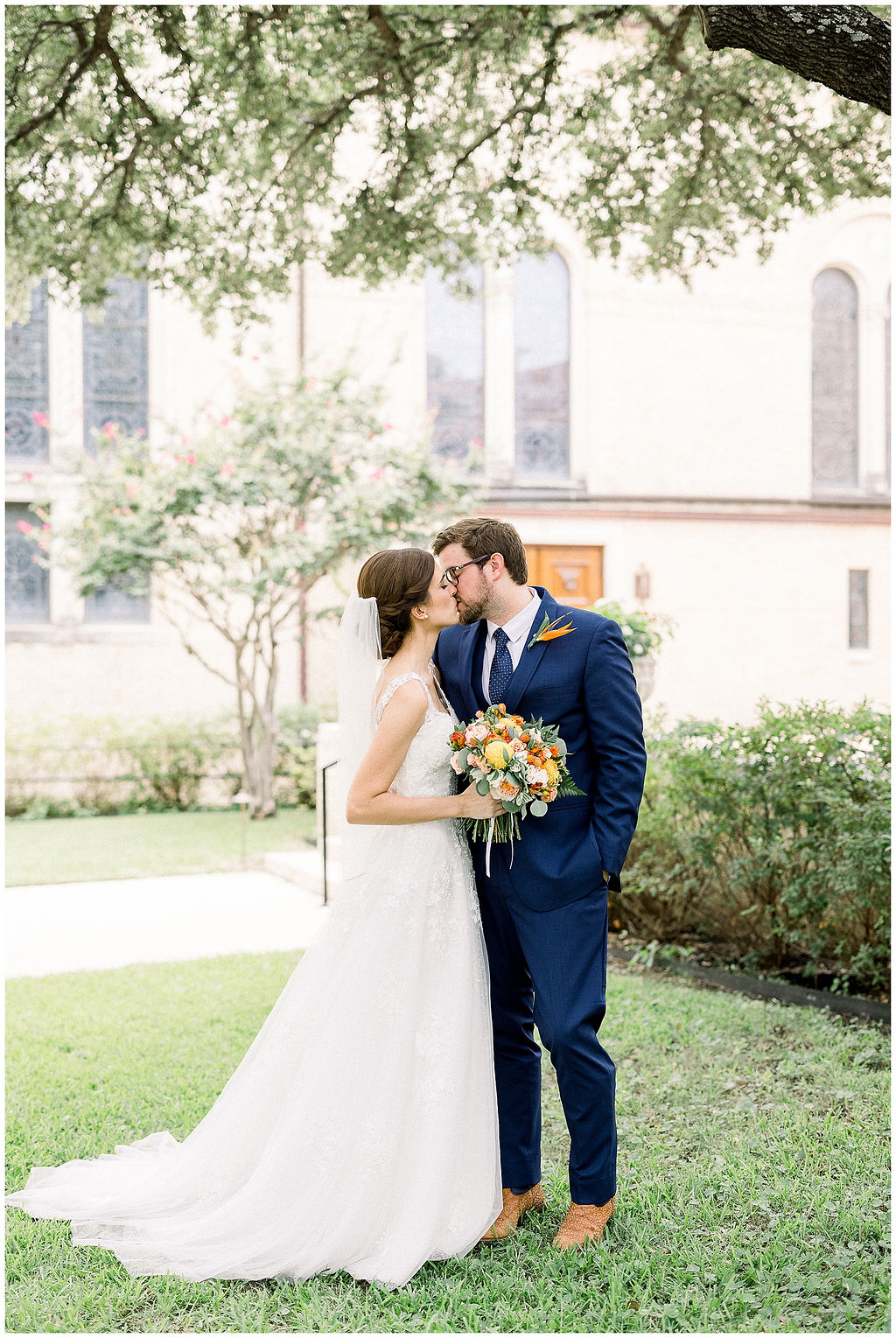 bride and groom kiss outside of chapel
